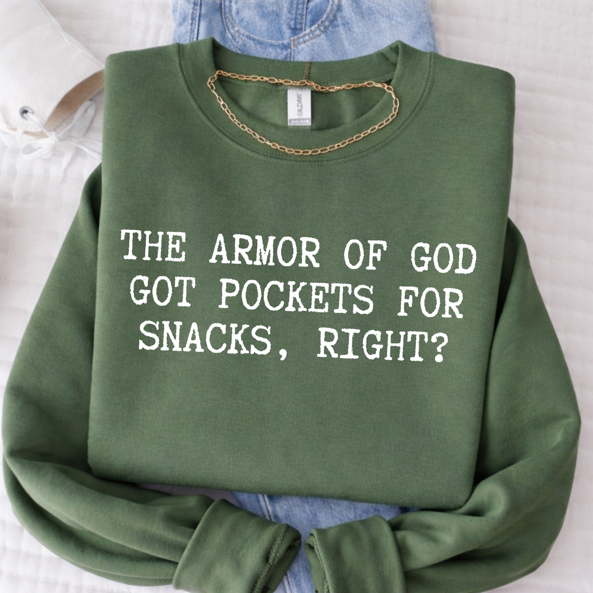 Green sweatshirt with text 'The Armor of God got pockets for snacks, right?' on a light background.
