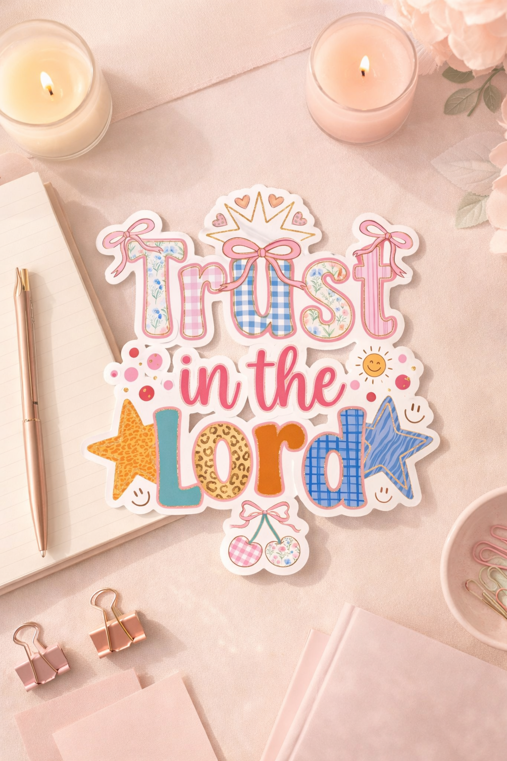 Decorative sticker with 'Trust in the Lord' text on a desk with candles and stationery.