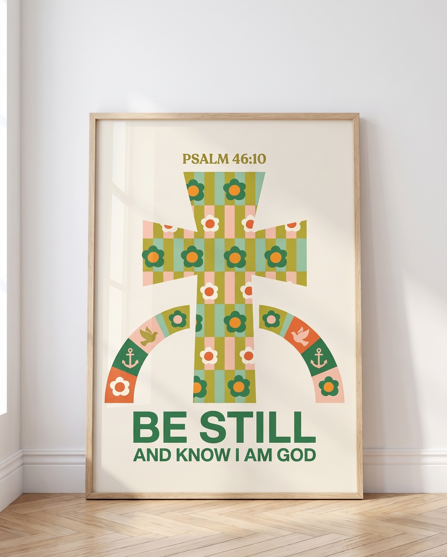 Scandinavian-style interior with an 11x14 wooden frame featuring a colorful Christian poster reading “Be Still and Know I Am God,” resting against the wall.