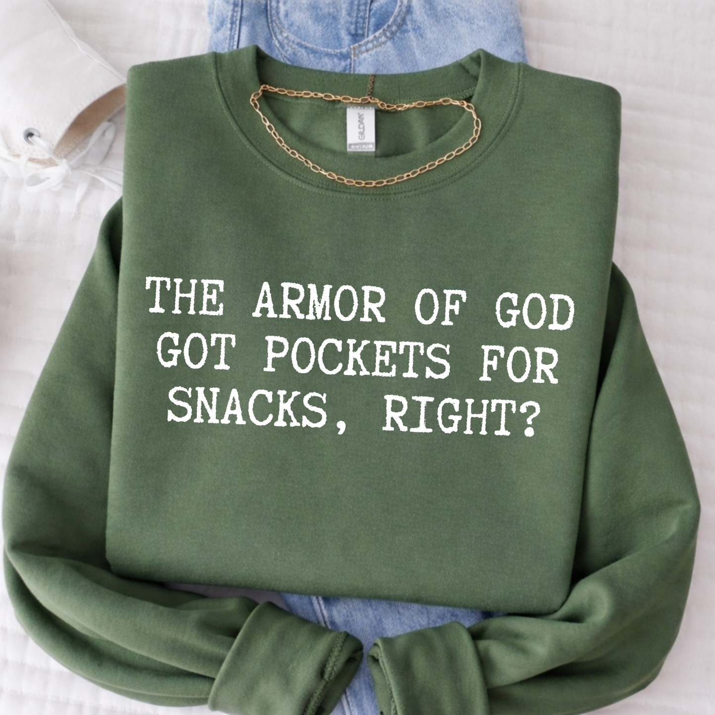 Green sweatshirt with text 'The Armor of God got pockets for snacks, right?' on a light background.