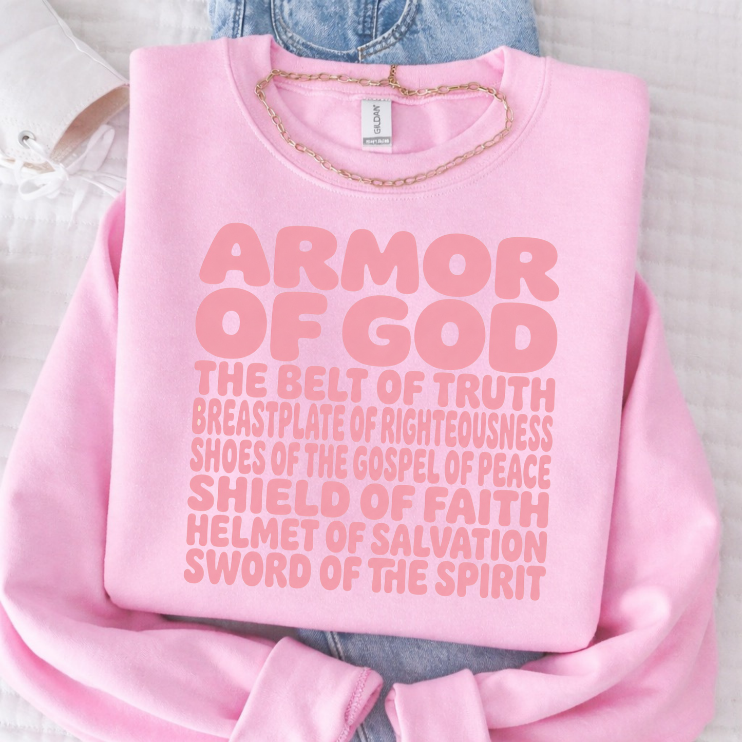 Pink sweatshirt with 'Armor of God' text on a light background
