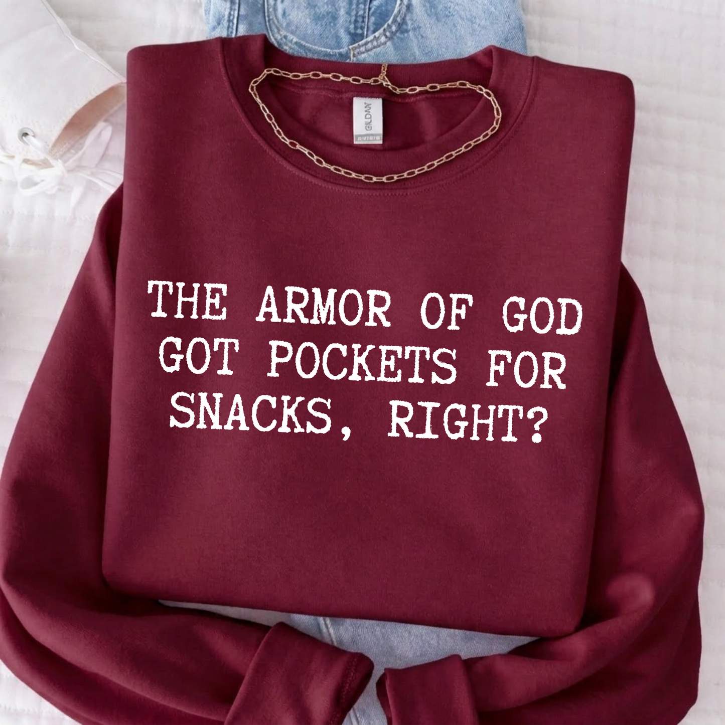 Maroon sweatshirt with text 'The Armor of God got pockets for snacks, right?' on a light background.
