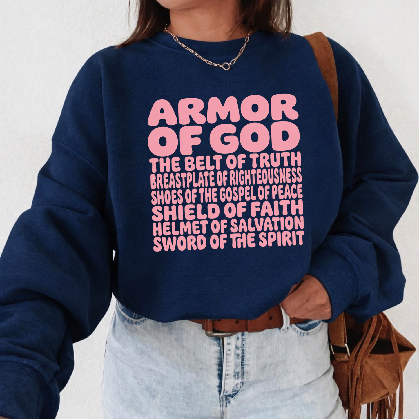 Person wearing a navy blue sweatshirt with 'Armor of God' text on a white background