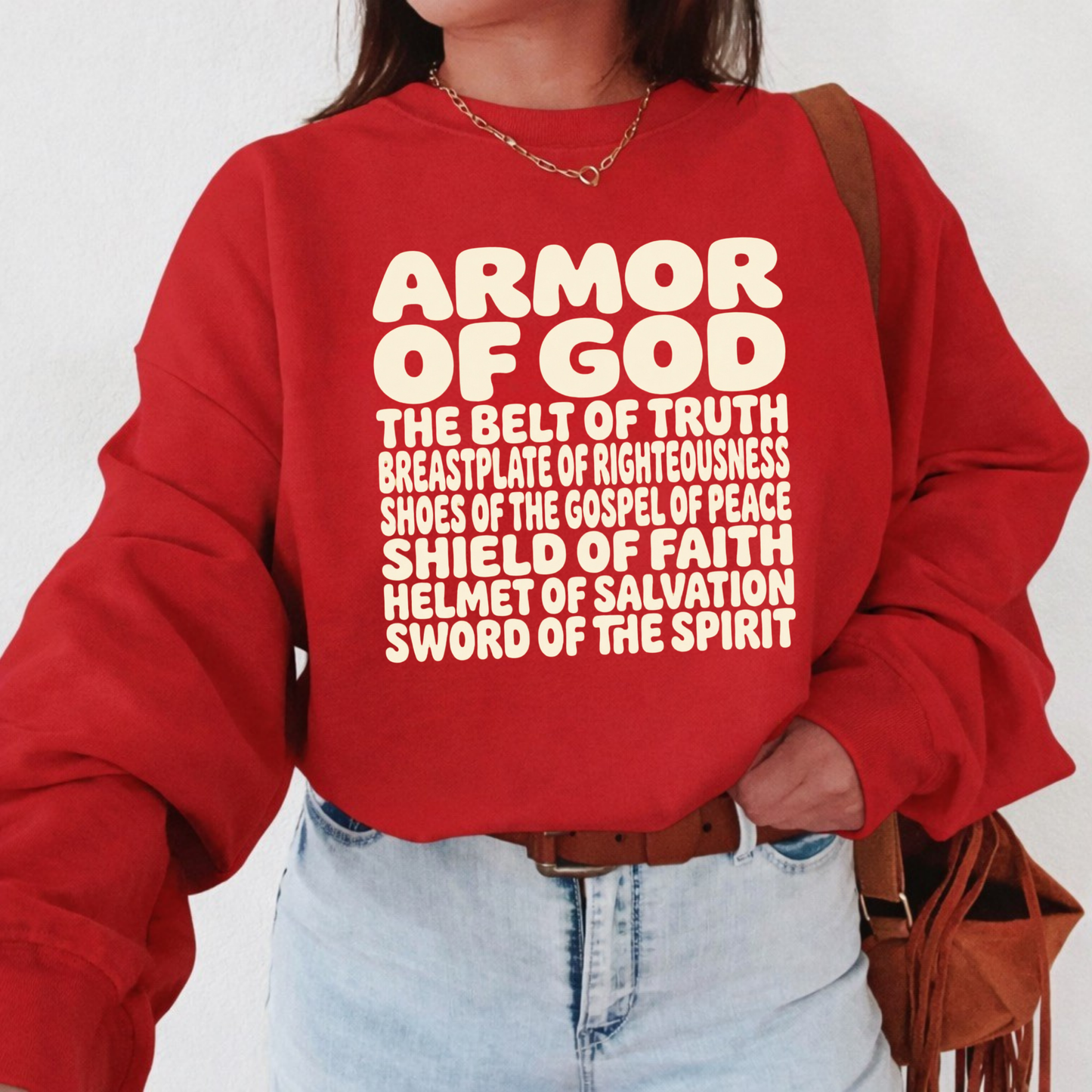 Person wearing a red sweatshirt with 'Armor of God' text on a white background