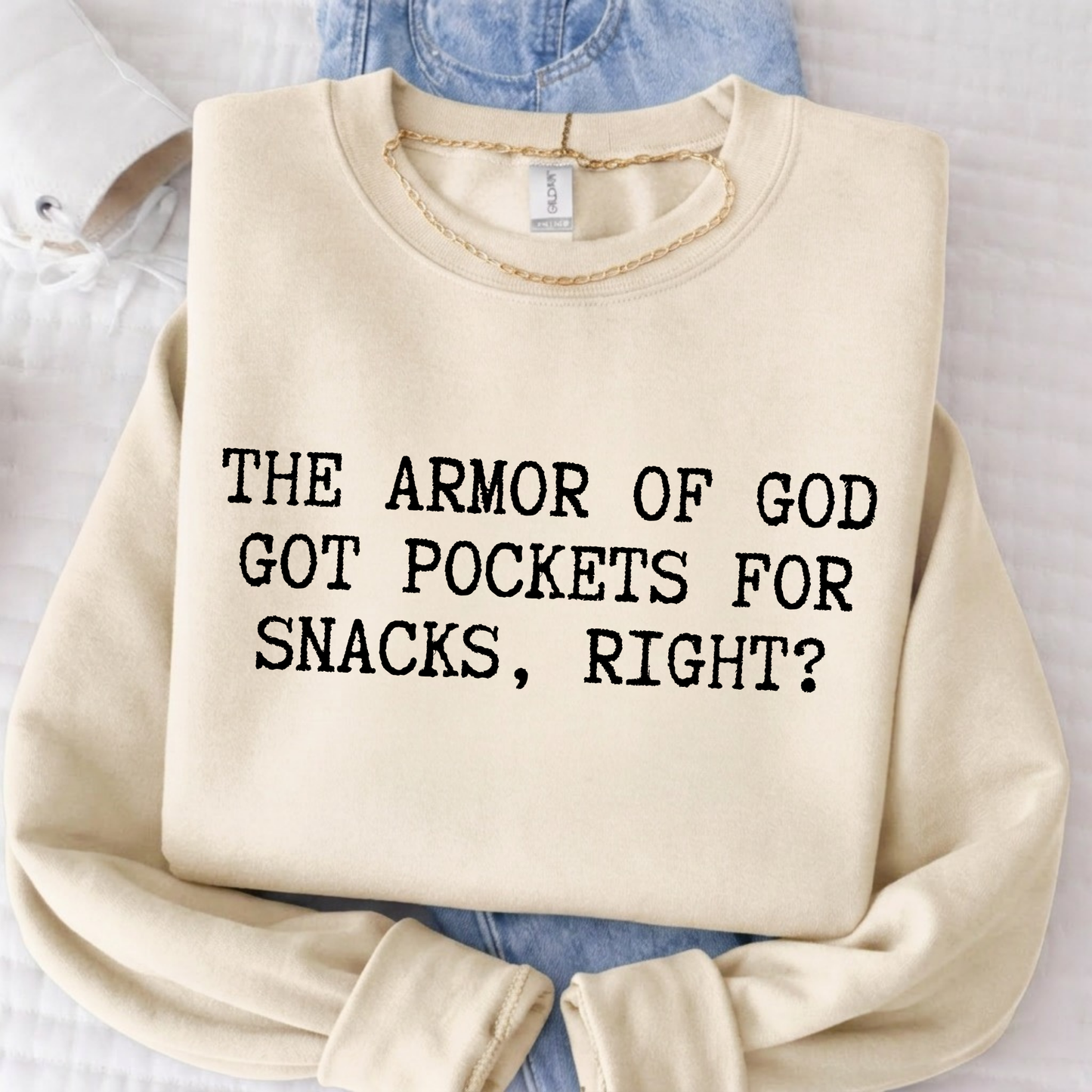 Beige sweatshirt with text 'The Armor of God got pockets for snacks, right?' on a light background.