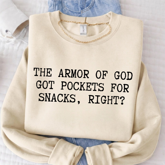 Beige sweatshirt with text 'The Armor of God got pockets for snacks, right?' on a light background.