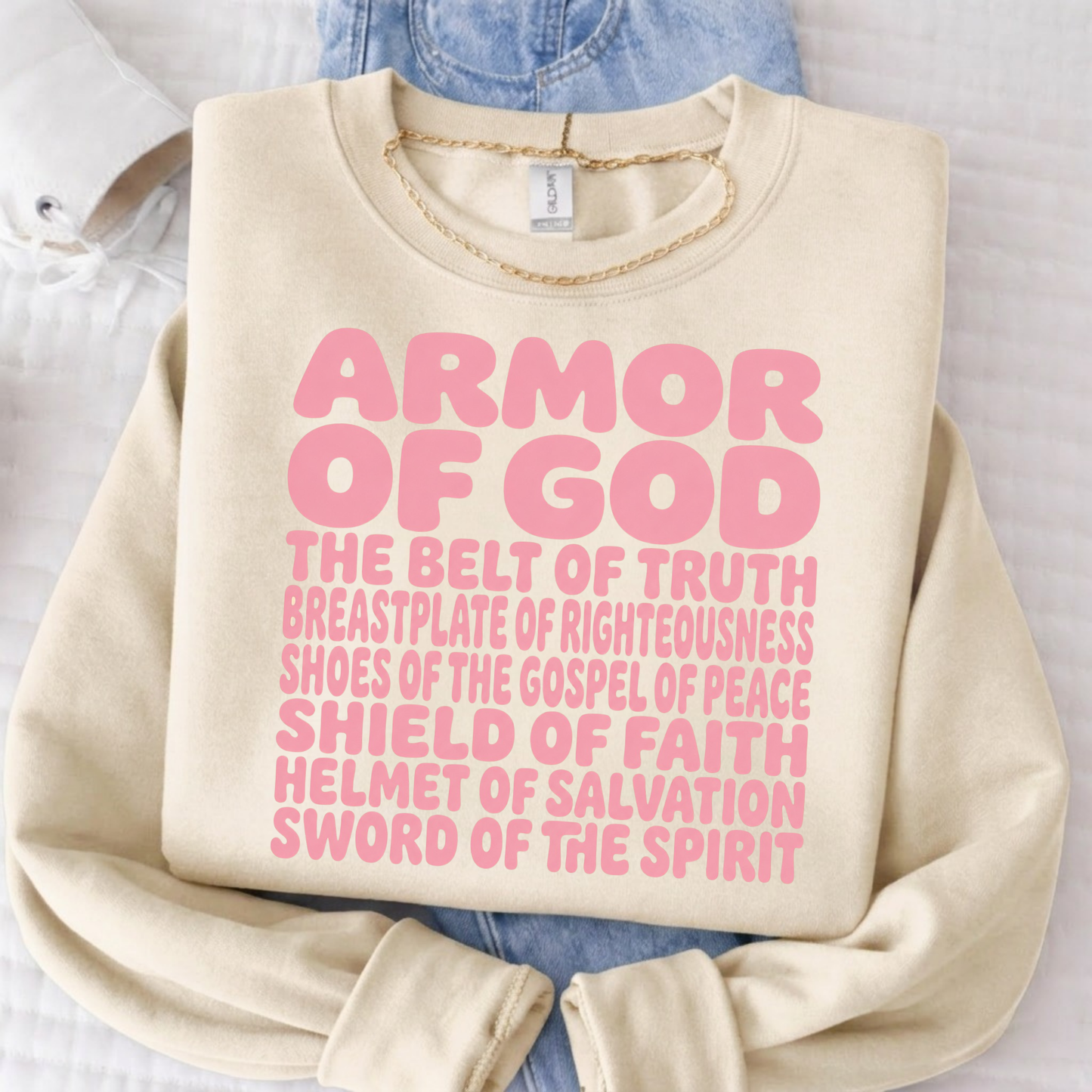 Person wearing a sand sweatshirt with 'Armor of God' text on a white background